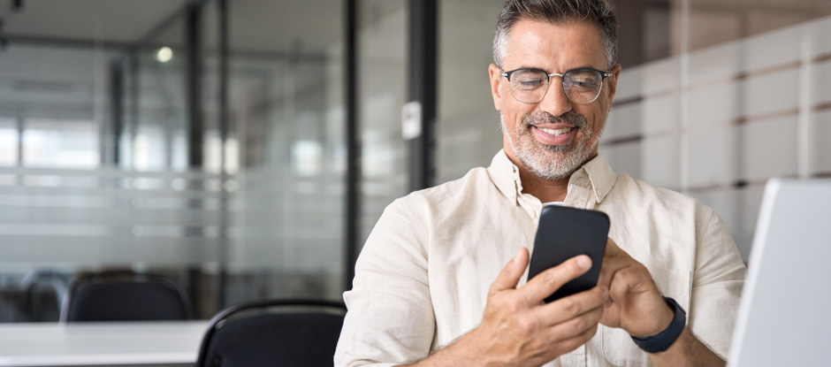 Man smiling while using digital banking app on phone.