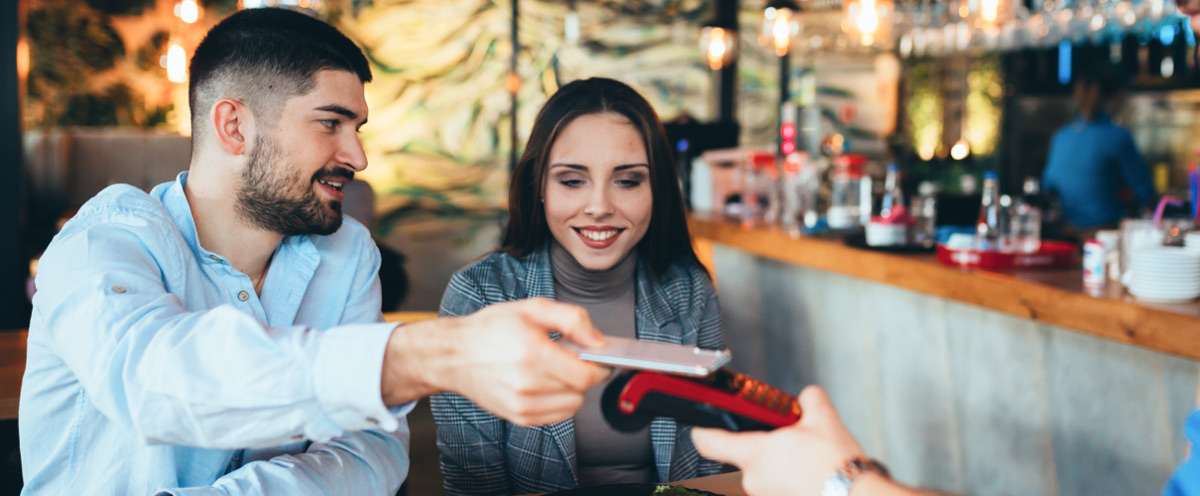 Couple using paying via digital payment software at a cafe