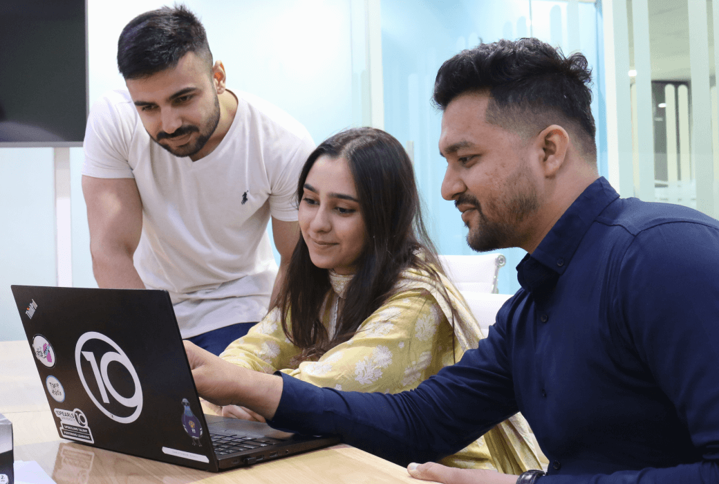 Software developers collaborating in an office, discussing outsourcing software development strategies.