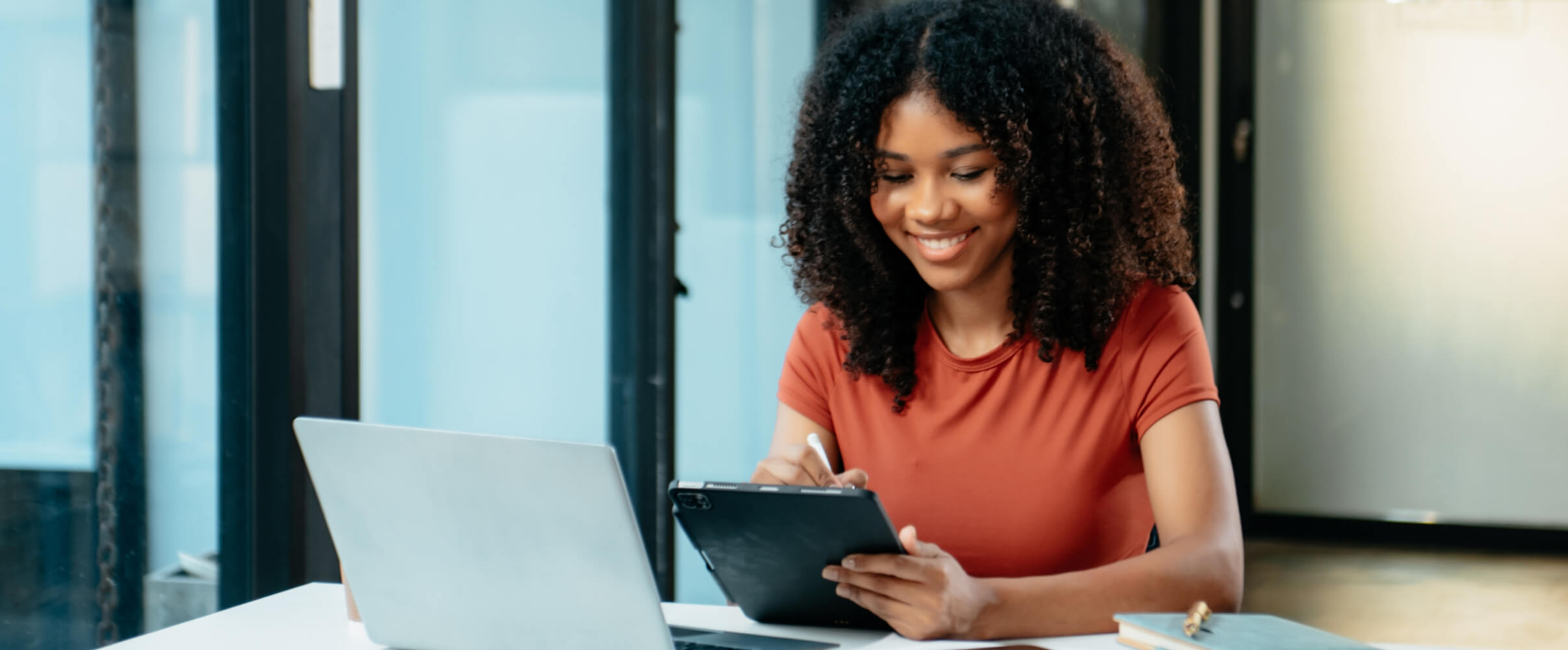 Woman who is part of the product development team working on tablet and smiling.