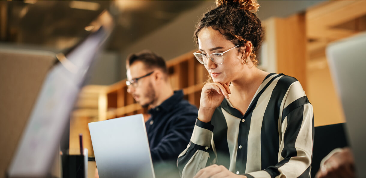 Woman sitting at laptop and working on client project.