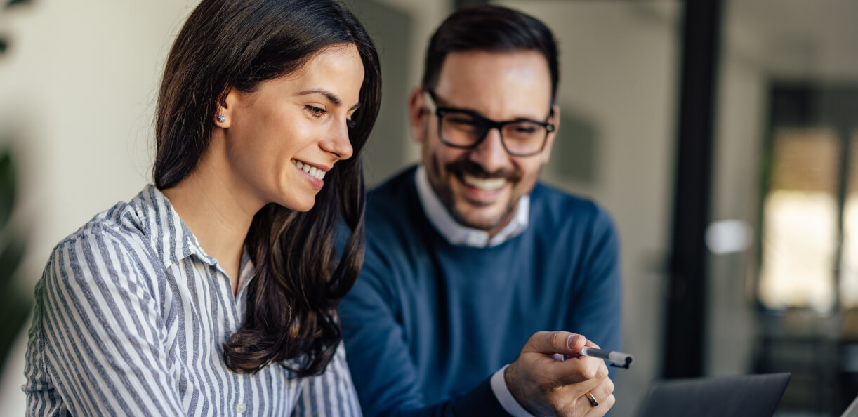 Two team members smiling and working together on client project.